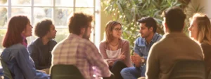 a group of people gathered in a circle, engaged in a deep discussion about psych-k facilitator training.