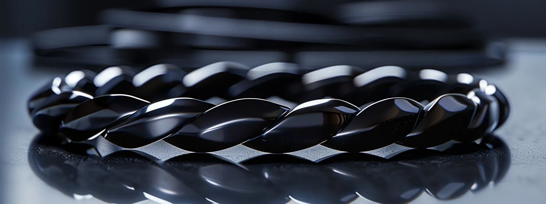 a close-up photo of a sleek onyx bracelet, showcasing its deep black color and glossy finish, set against a backdrop of shimmering sterling silver.